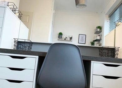 Modern beauty workspace at Kailey’s Beauty Room, Lowestoft, England, GB with sleek white drawers and black chair.