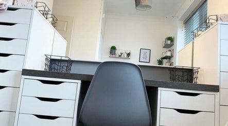 Modern beauty workspace at Kailey’s Beauty Room, Lowestoft, England, GB with sleek white drawers and black chair.