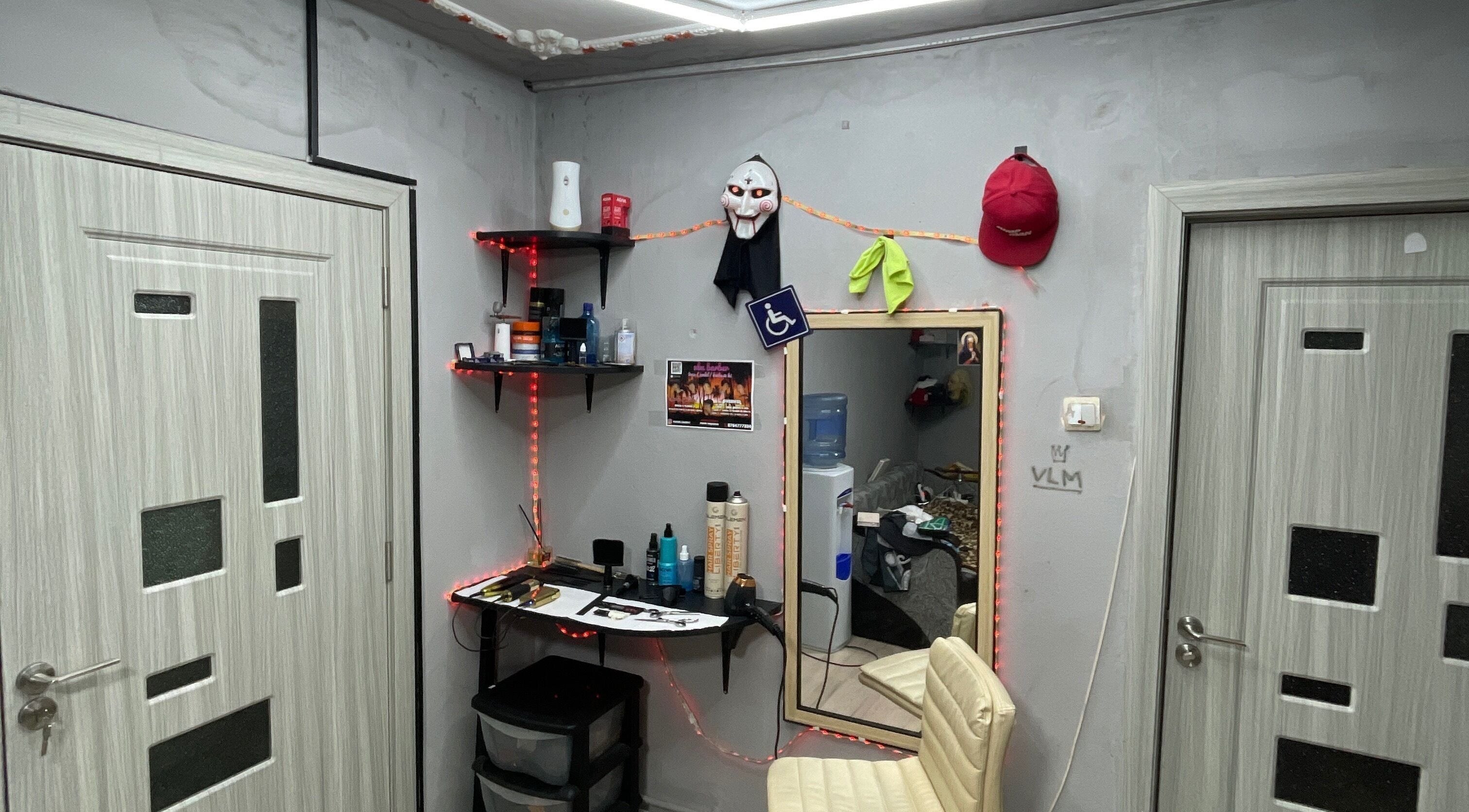 Interior modern la VLM Barber în București, RO, cu scaun alb și rafturi.