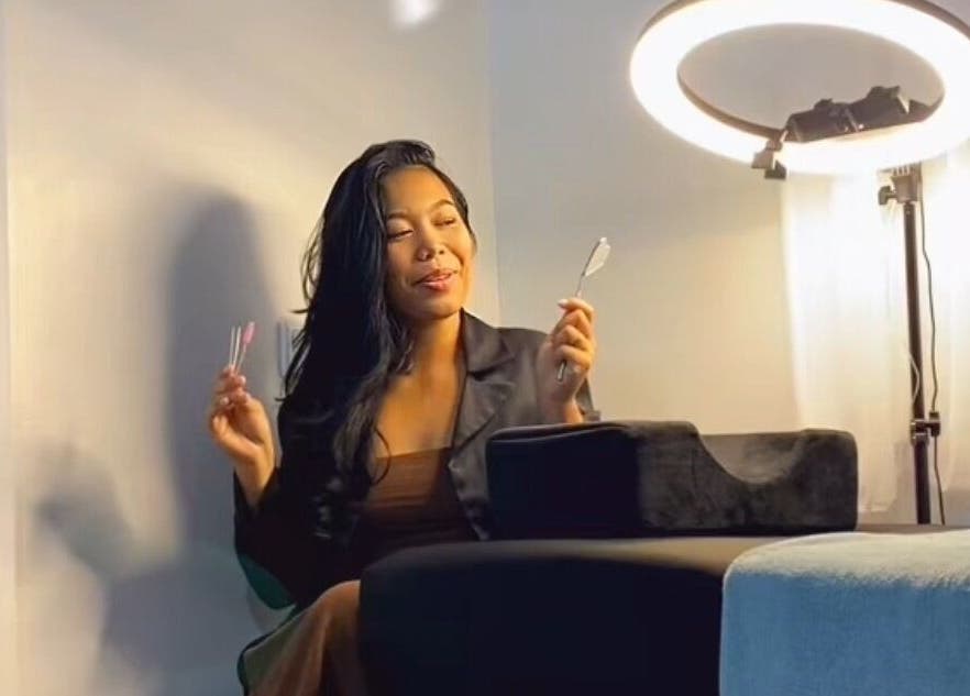 Vrouw in Doll Eye Studio, Paramaribo, ontspannen onder ringlicht tijdens een schoonheidsbehandeling.