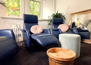 Cozy lounge area at Little Pigeon Massage and Waxing, Melbourne, Victoria, AU featuring blue chairs and plants.