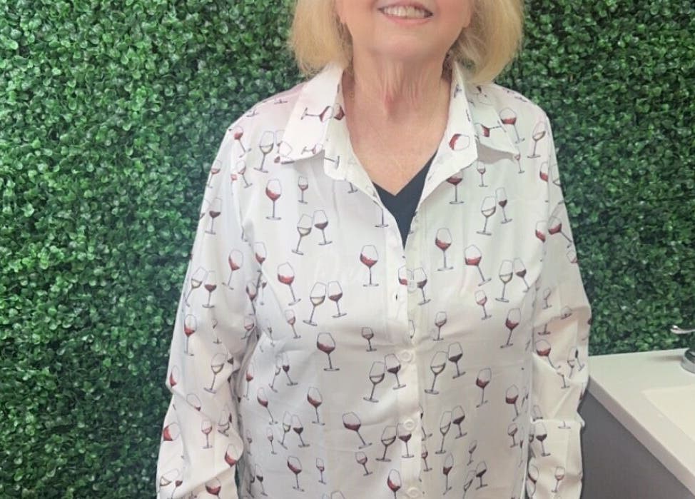 Woman smiling in front of green wall at Better u lash in Moore, Oklahoma, US.