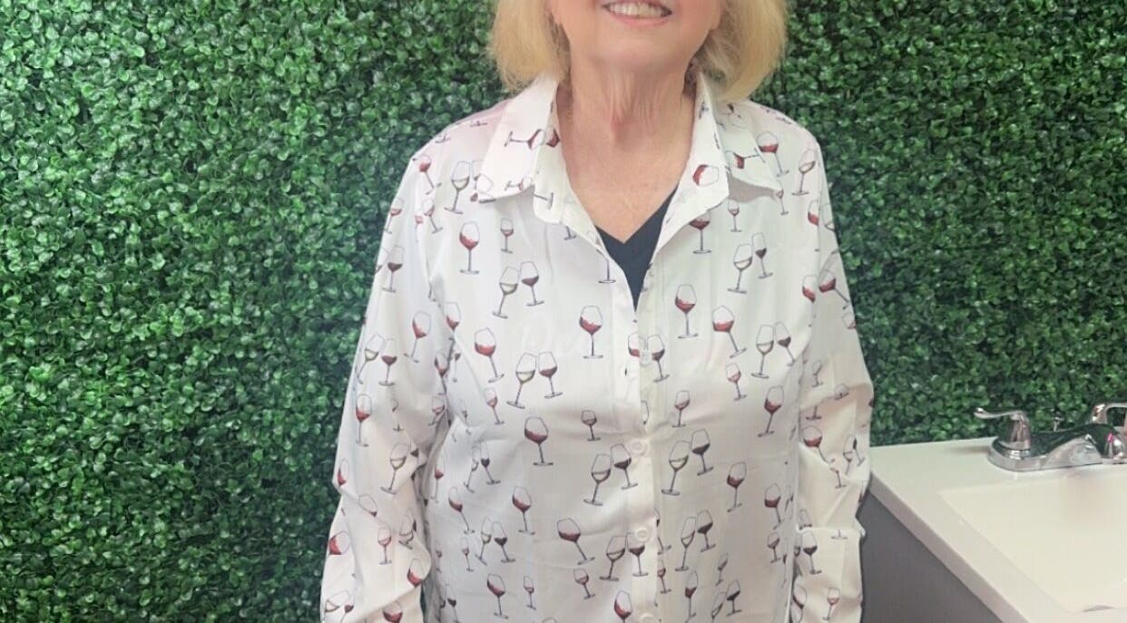 Woman smiling in front of green wall at Better u lash in Moore, Oklahoma, US.