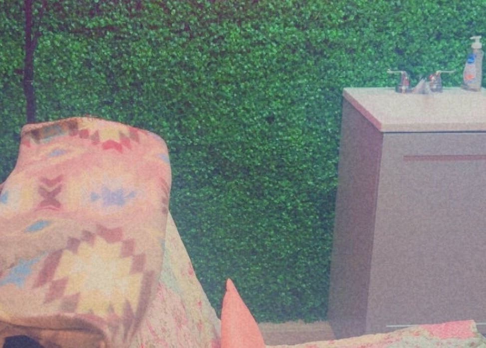 Cozy spa room at Better U Lash, Moore, Oklahoma, US with lush green wall and relaxation area.