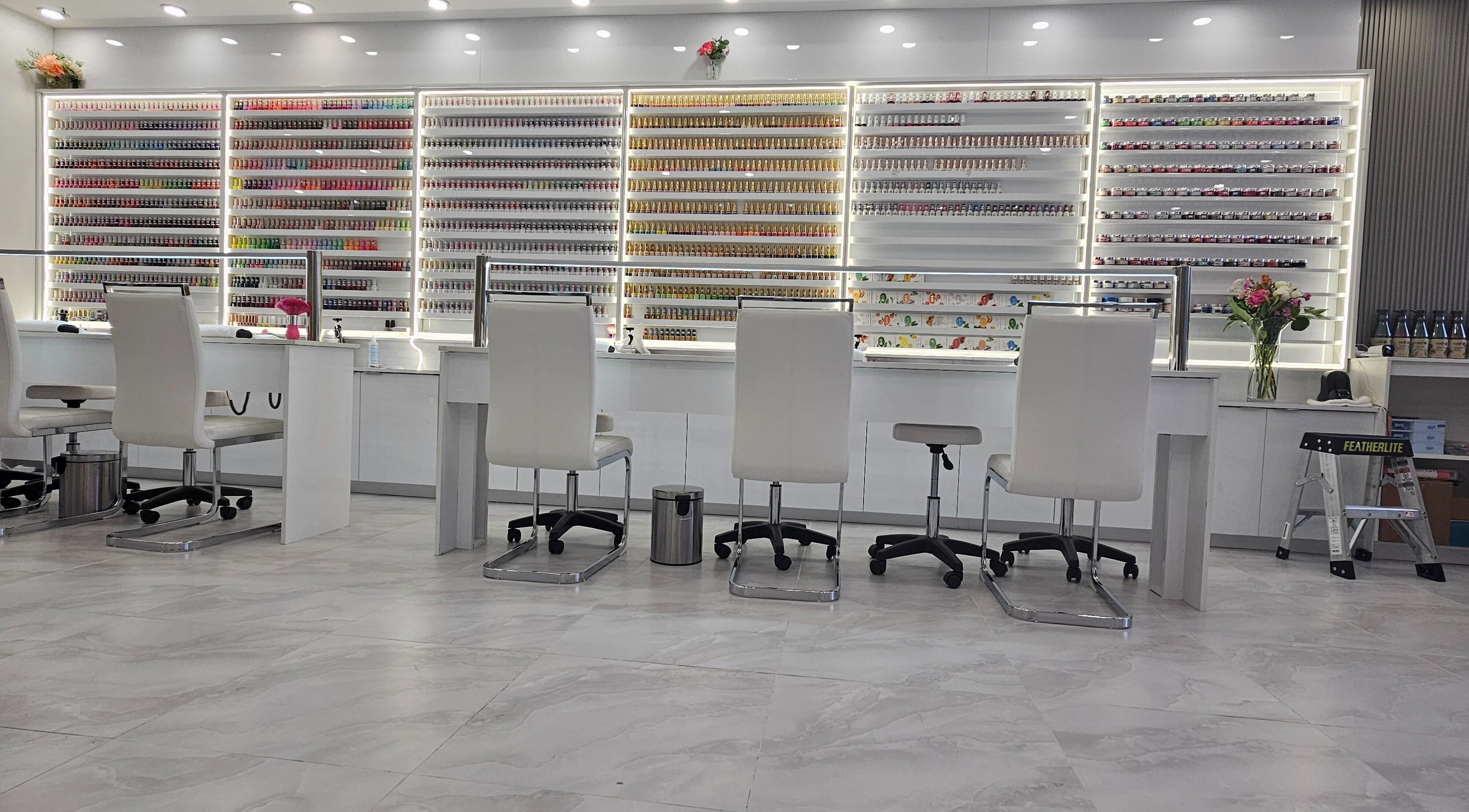 Bright, chic interior of All Season Nails (Westview), Vancouver, BC, featuring elegant workstations and polish displays.