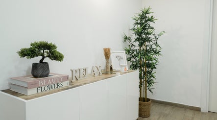 Chic decor at Lune Noire Beauty, Ir-rabat Għawdex, MT featuring plants, books, and a relax sign.
