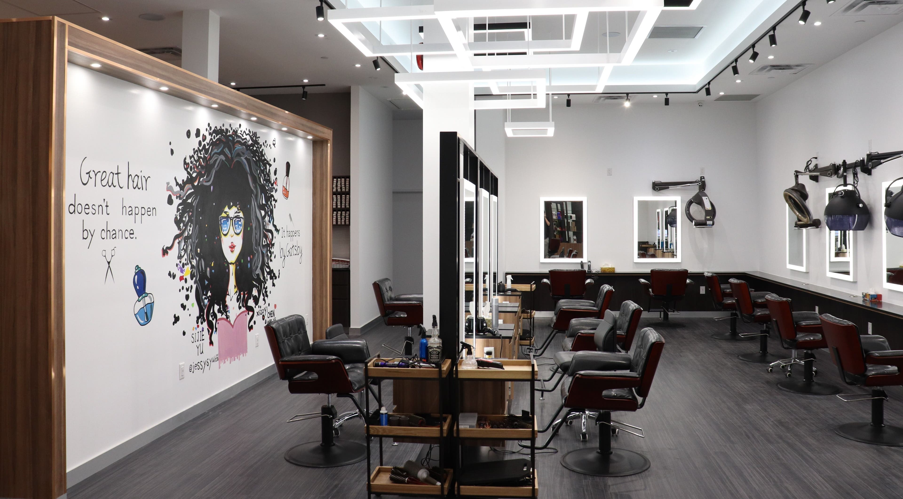 Interior of Gatsby Studio Salon & Spa Markville, Markham, Ontario, CA with modern chairs and artistic wall mural.
