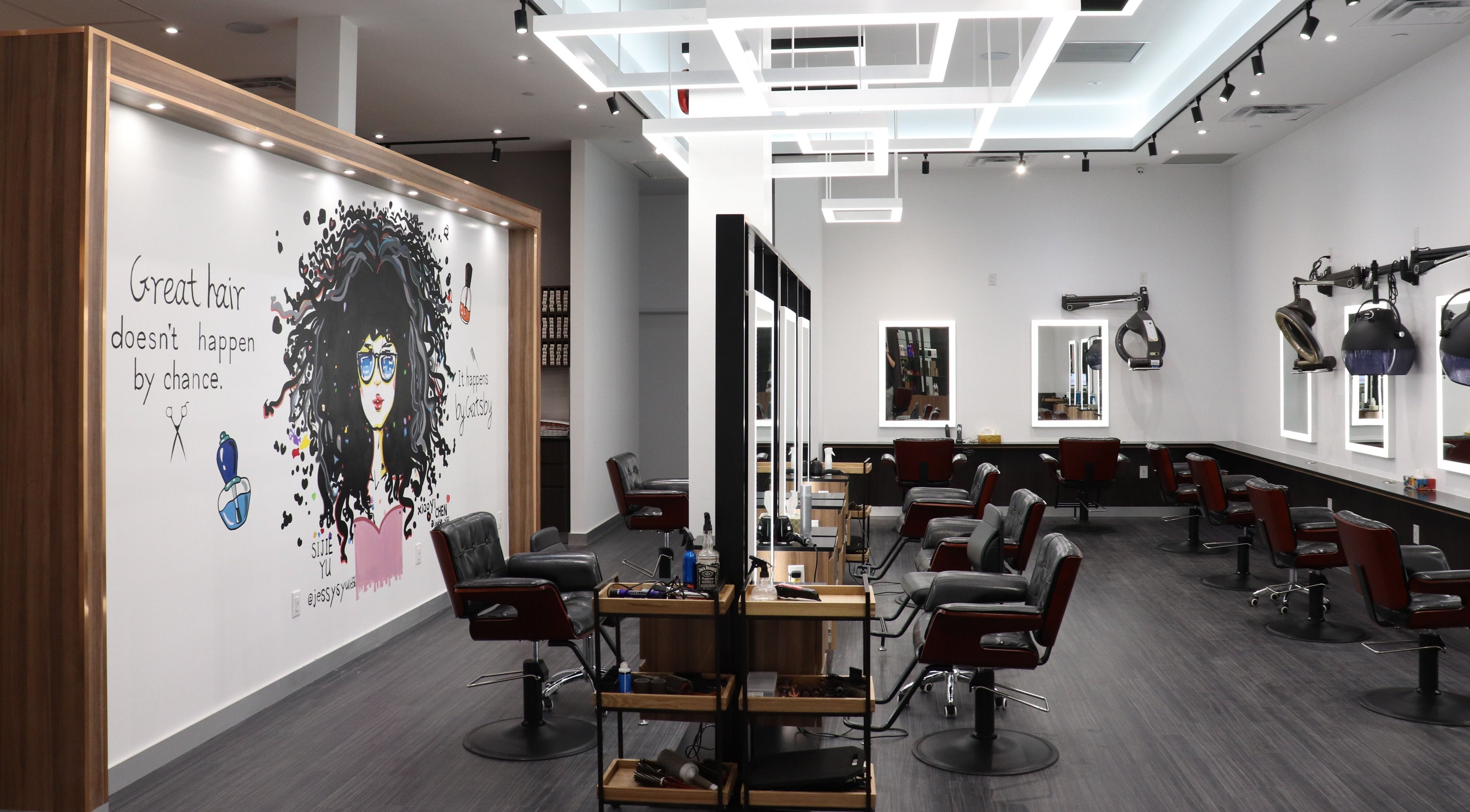 Interior of Gatsby Studio Salon & Spa Markville, Markham, Ontario, CA with modern chairs and artistic wall mural.