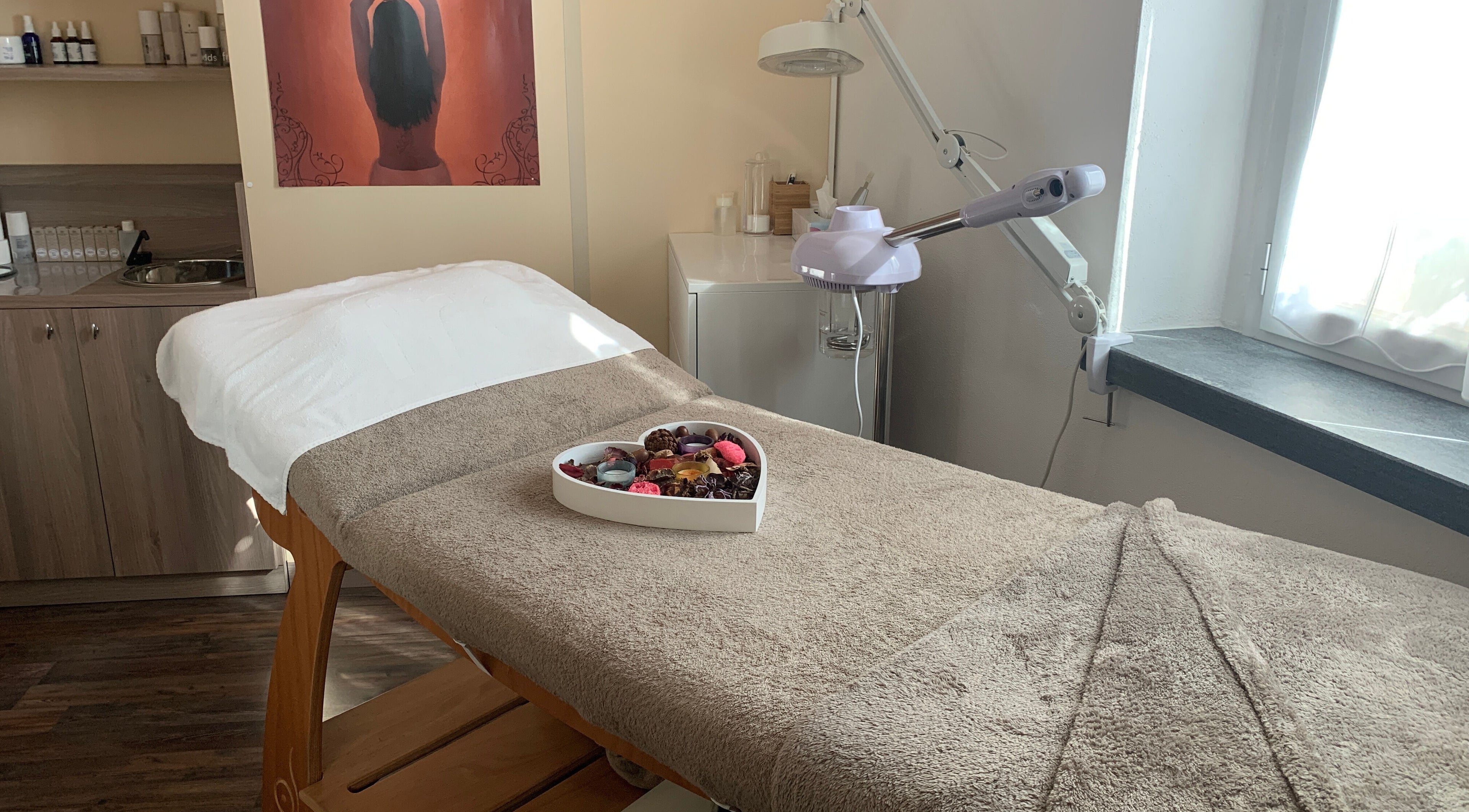 Stanza di trattamenti Bellezza Naturale, Bissone, Ticino, CH. Letto di massaggio e decorazioni rilassanti.