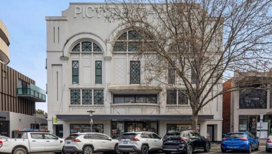 Street view of Tana Hair & Make Up, an elegant building in Melbourne, Victoria, AU with cars parked outside.
