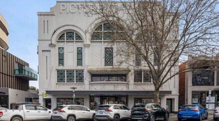 Street view of Tana Hair & Make Up, an elegant building in Melbourne, Victoria, AU with cars parked outside.