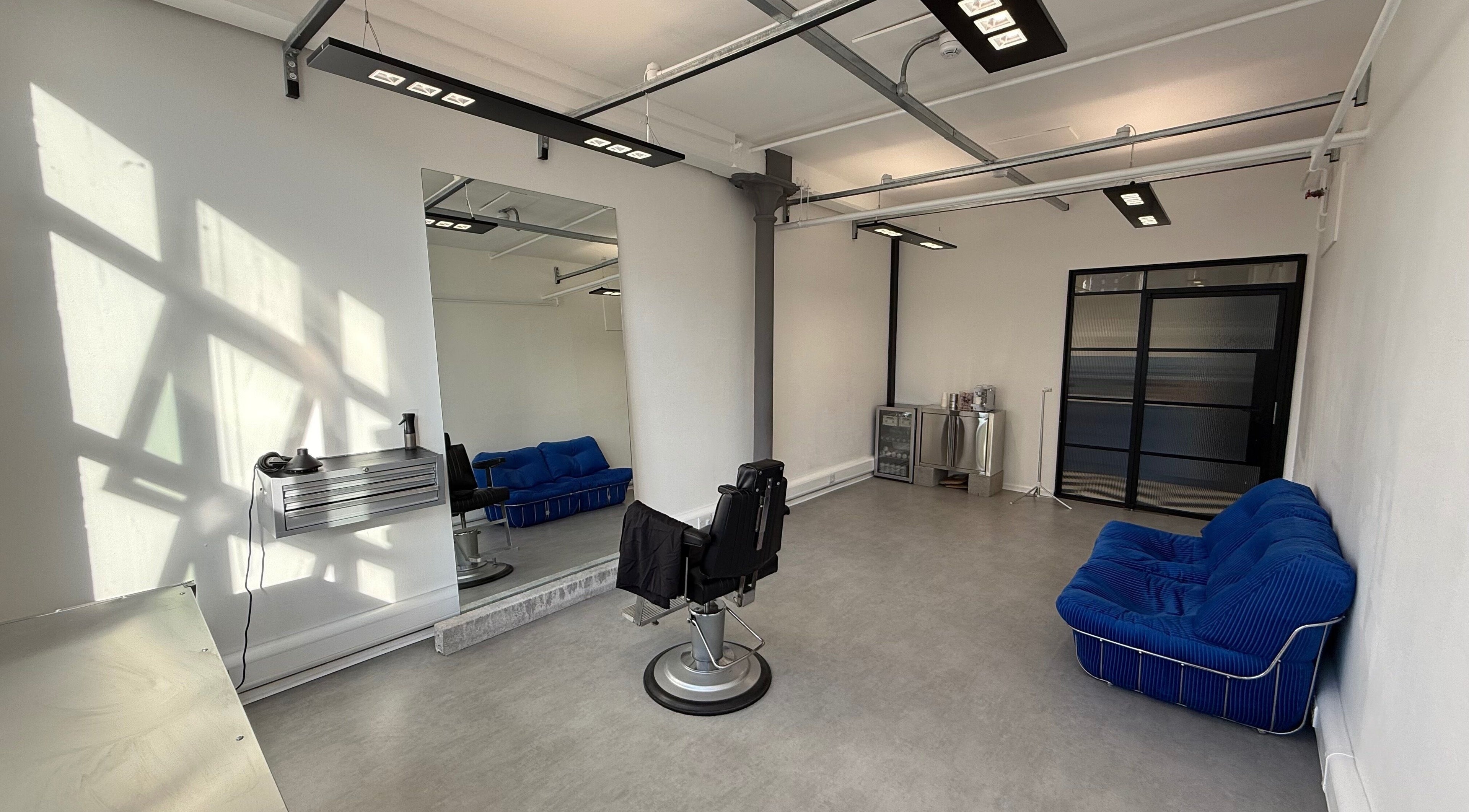 Chic interior of STUDIO 3266, Manchester, England, GB with a modern chair, sofa, and industrial lighting.