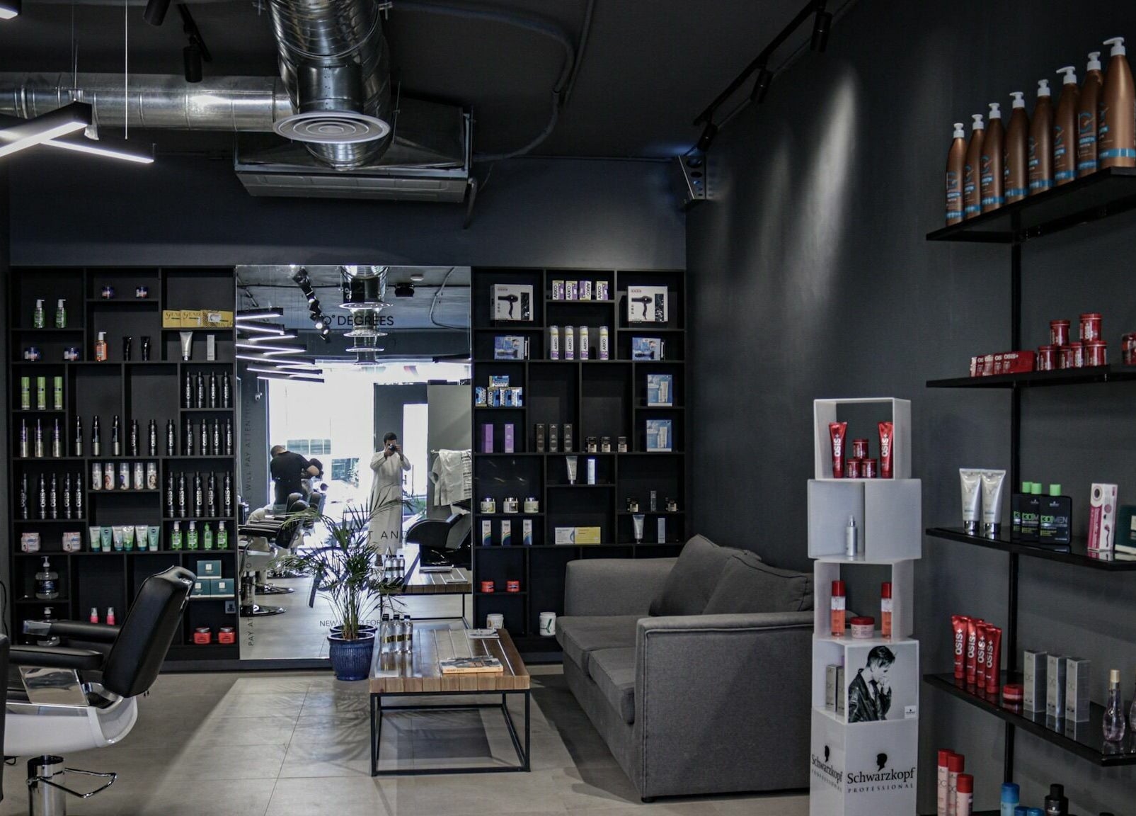 Interior of Al Rayan | 30 Degrees Barbershop, Riyadh. Chic design with product displays and styling chairs.