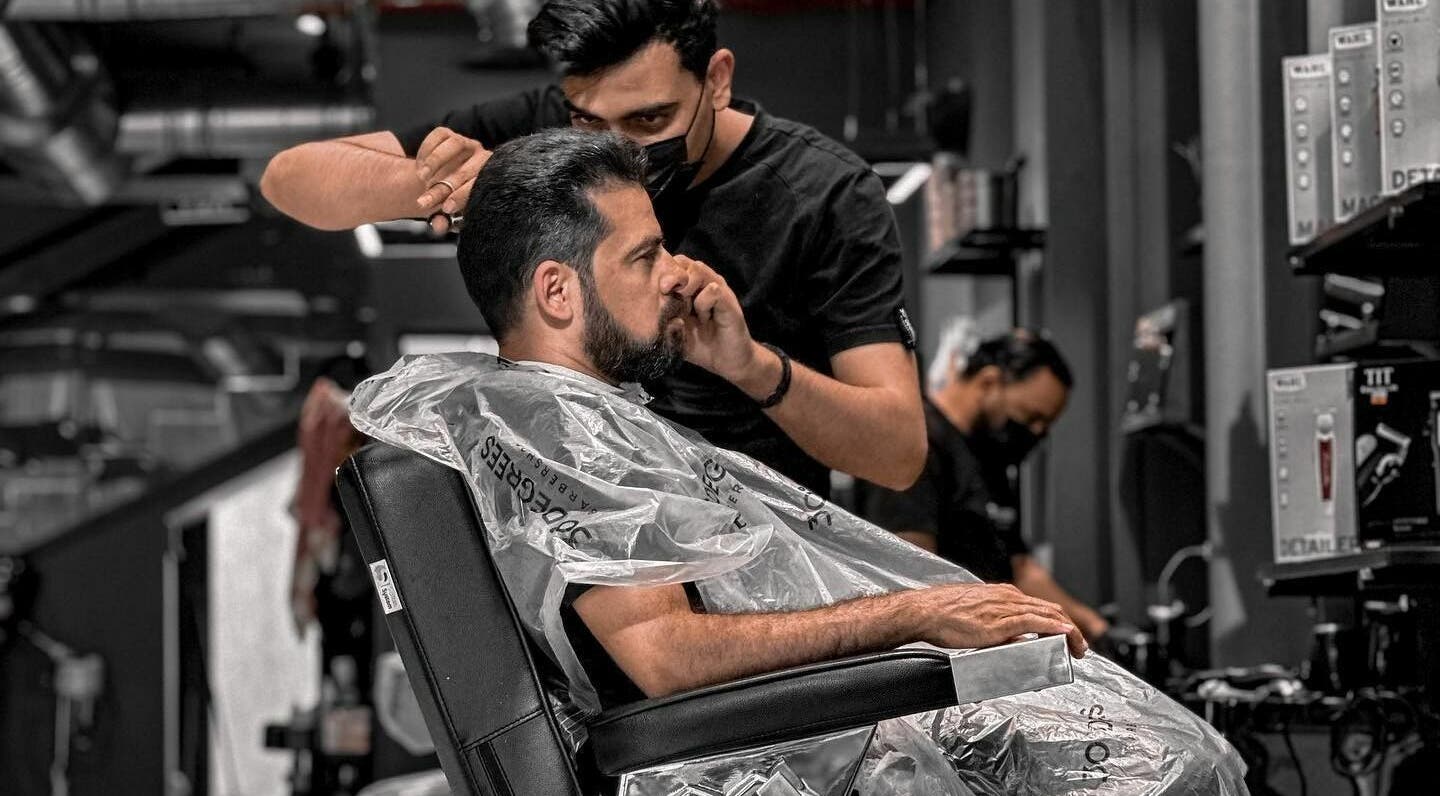 Expert barber at Al Rayan | 30 Degrees Barbershop in Riyadh, Saudi Arabia, styling a client's hair.