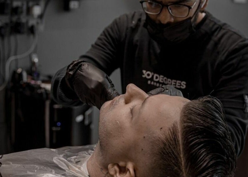 Barber at Al Khobar 30 Degrees Barbershop | Olaya Branch in Al Khobar, Eastern Province, SA, styling a client's hair.