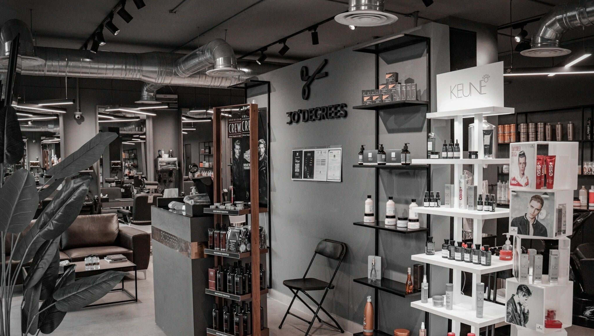 Interior view of Al Mohamadyah 30 Degrees Barbershop, Riyadh, showcasing sleek design and product displays.