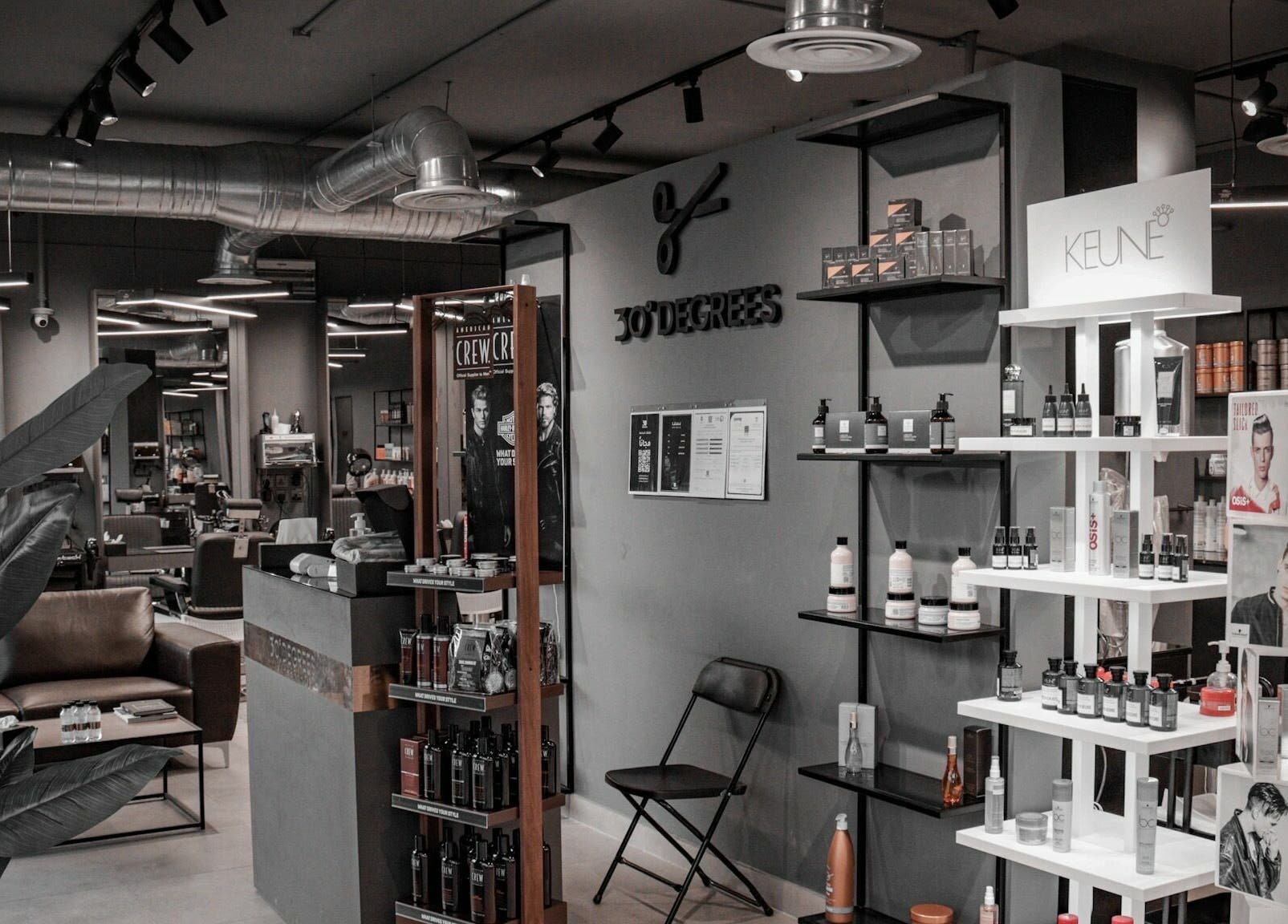 Interior view of Al Mohamadyah 30 Degrees Barbershop, Riyadh, showcasing sleek design and product displays.
