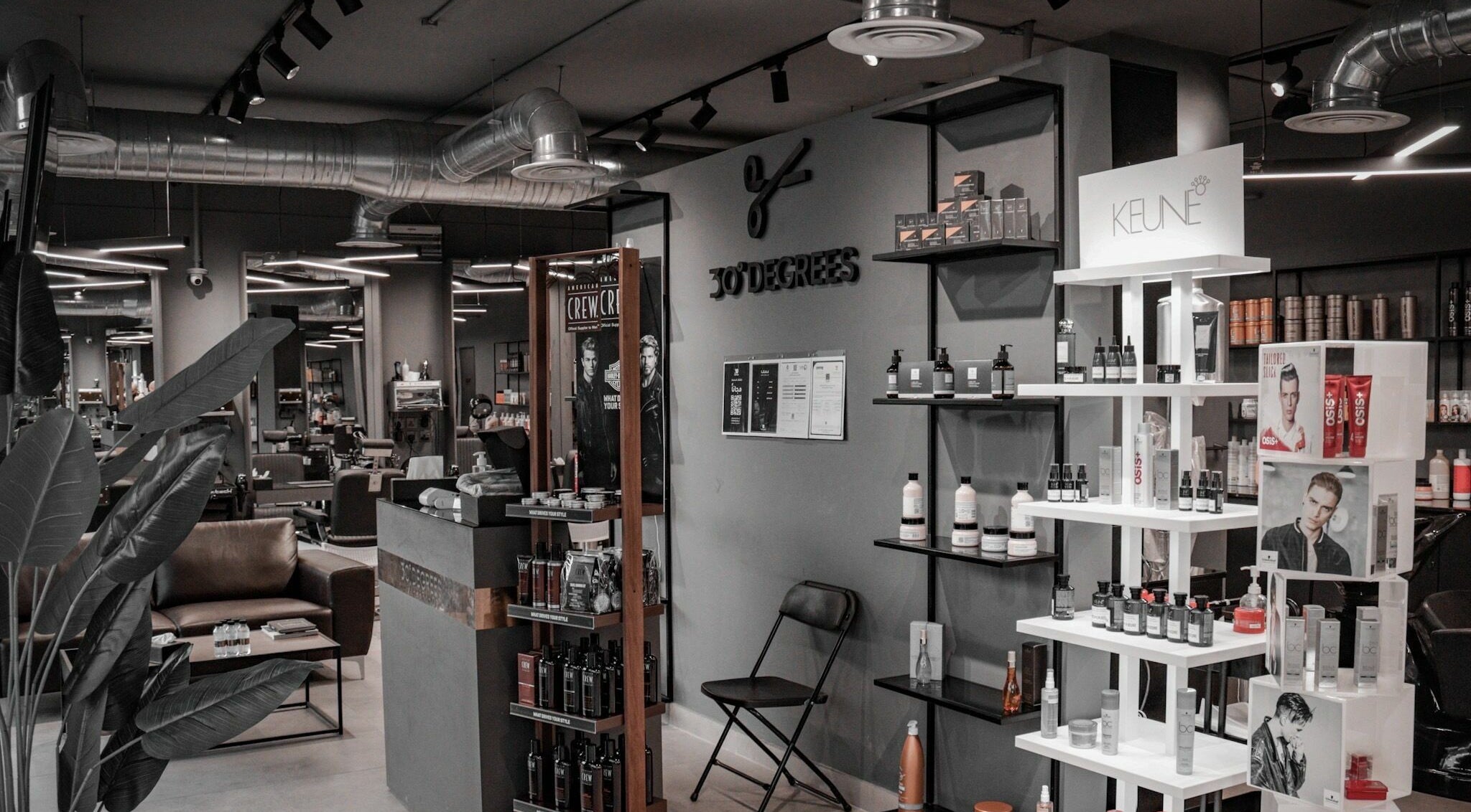 Interior view of Al Mohamadyah 30 Degrees Barbershop, Riyadh, showcasing sleek design and product displays.