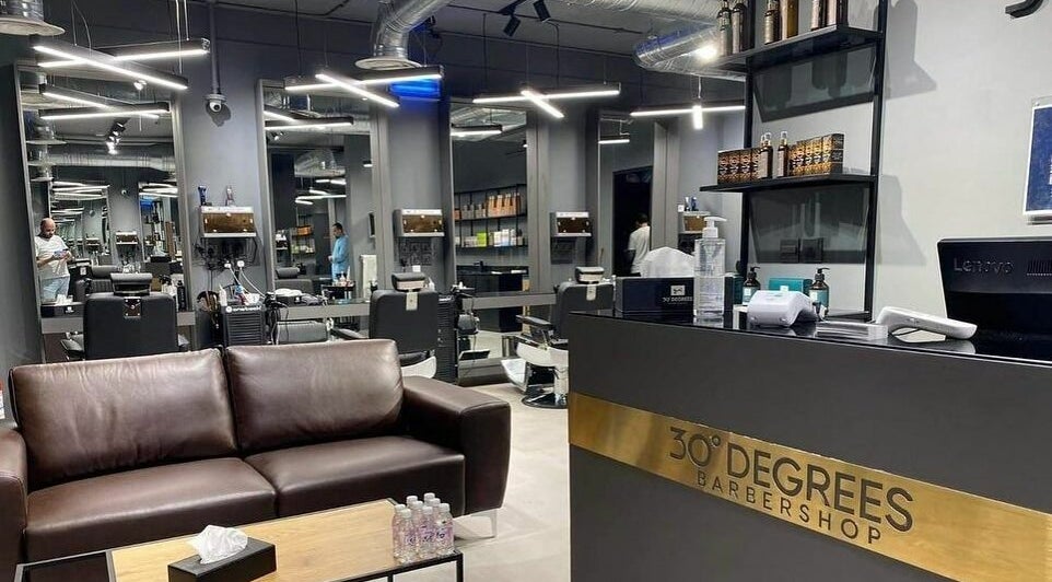 Modern interior of AlUla 30 Degrees Barbershop, elegant seating, mirrors, and grooming stations in AlUla, Eastern Province, SA.