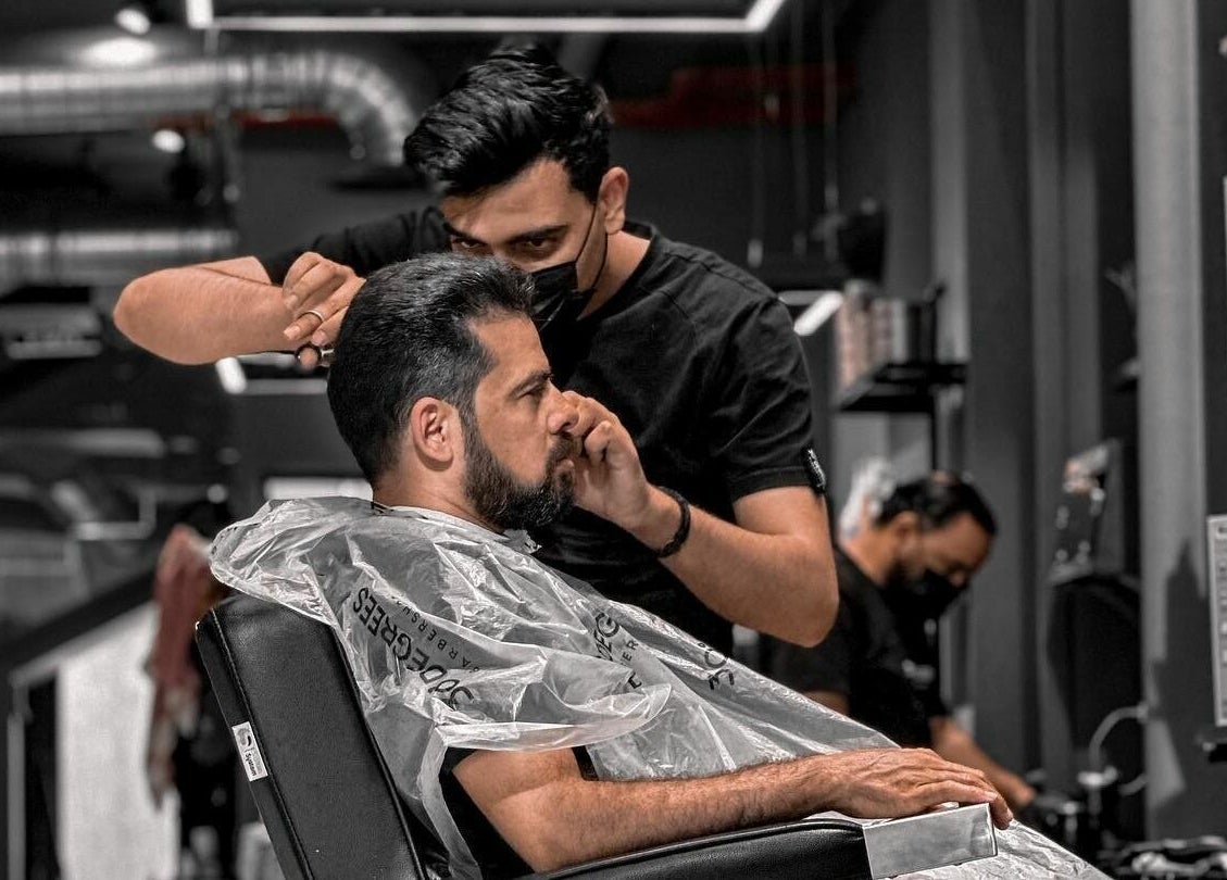 Barber perfecting a stylish beard trim at AlUla 30 Degrees Barbershop, AlUla, Eastern Province, SA.