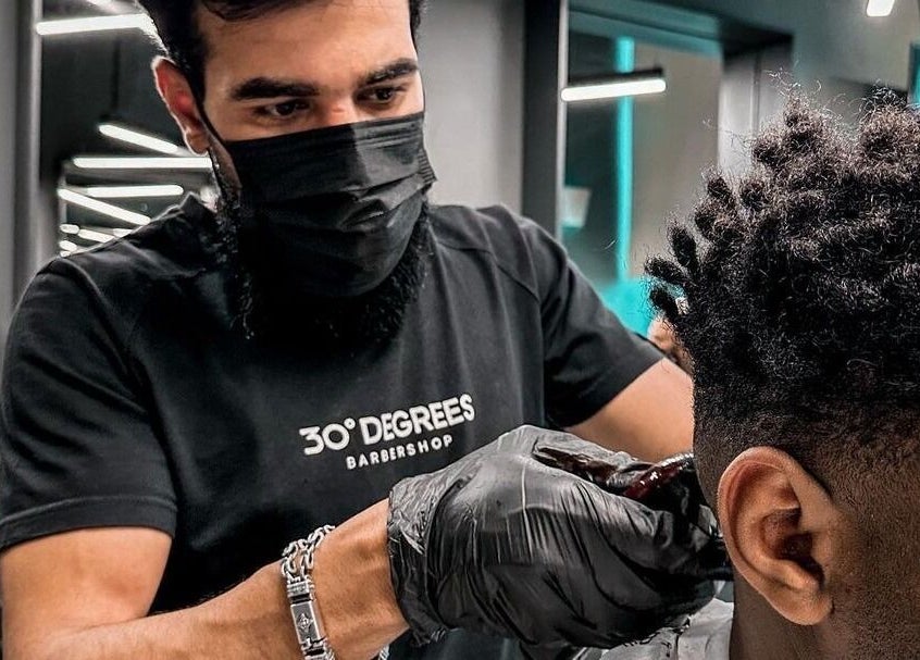 Barber at Al Malqa 30 Degrees styling a client's hair in Riyadh, Riyadh Province, SA.