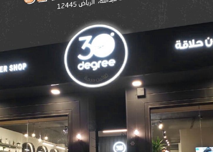 Entrance of 30 Degrees Clock Tower barber shop in Makkah, Makkah Province, SA at night.