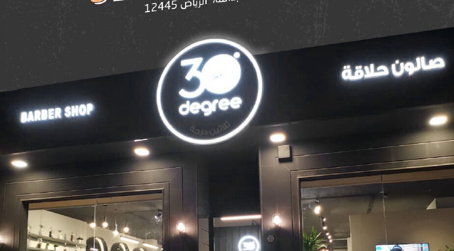 Entrance of 30 Degrees Clock Tower barber shop in Makkah, Makkah Province, SA at night.