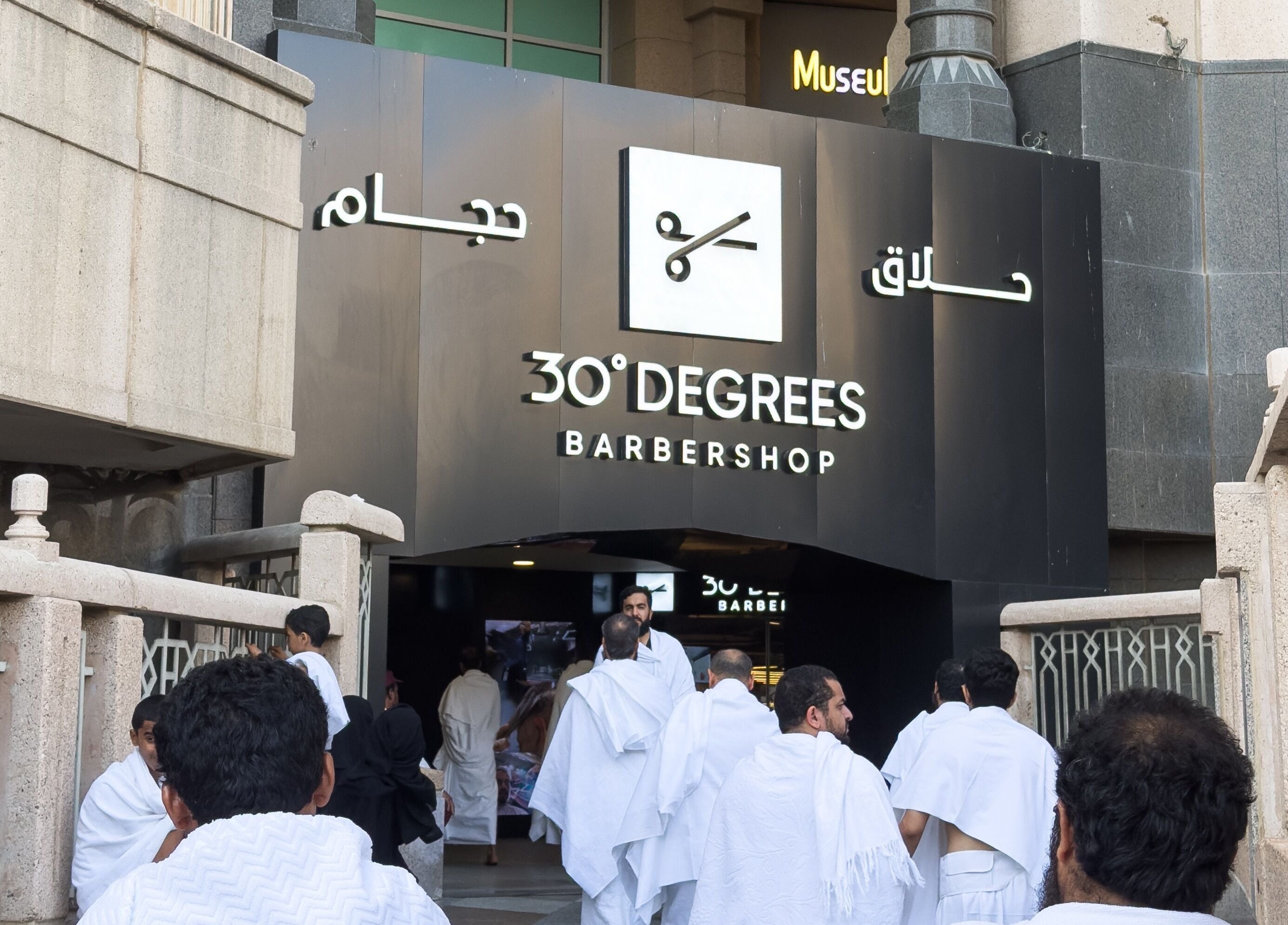 Entrance to 30 Degrees Clock Tower Barbershop, Makkah, Makkah Province, SA with visitors arriving.