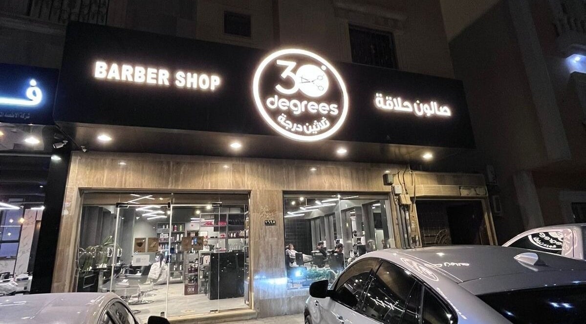 Exterior view of Qurtubah 30 Degrees barber shop in Riyadh, Riyadh Province, SA with illuminated signage.