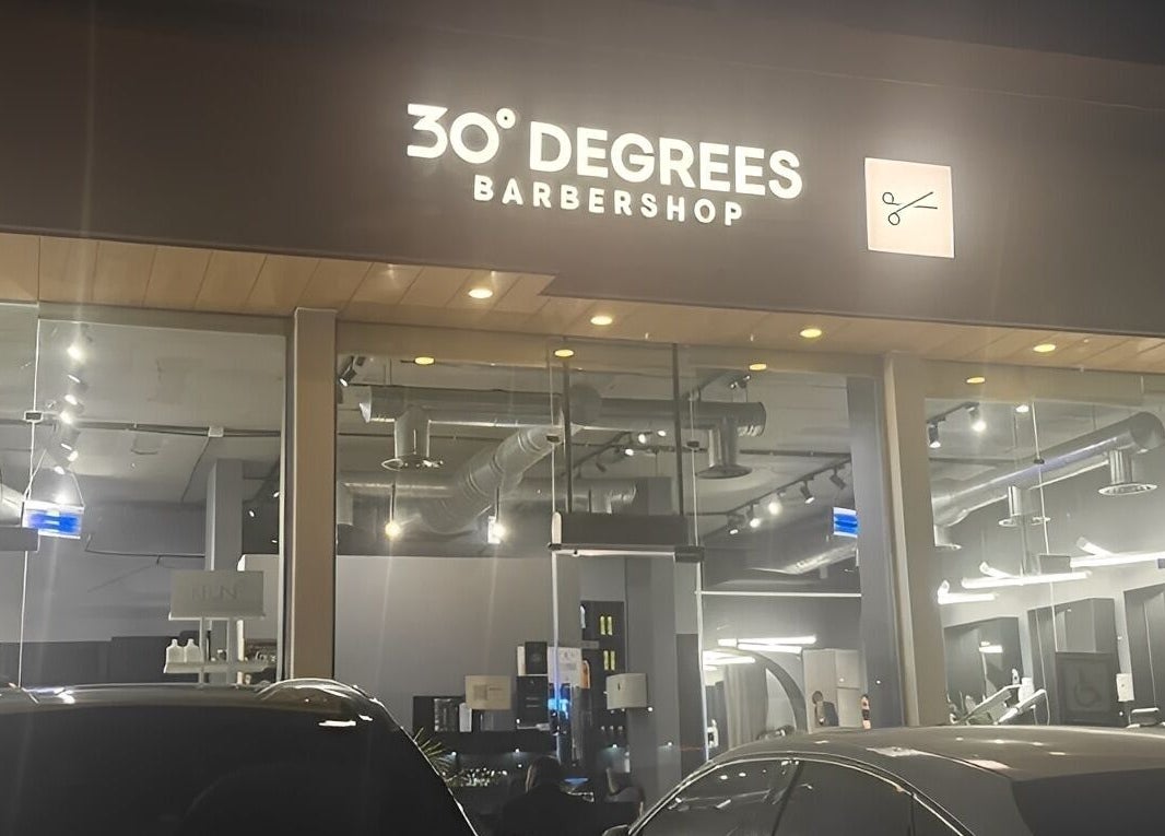 Exterior of AlYasmin 30 Degrees barbershop in Riyadh, Saudi Arabia, SA, illuminated signage at night.