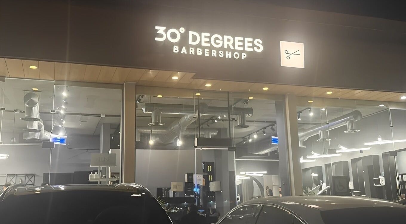 Exterior of AlYasmin 30 Degrees barbershop in Riyadh, Saudi Arabia, SA, illuminated signage at night.