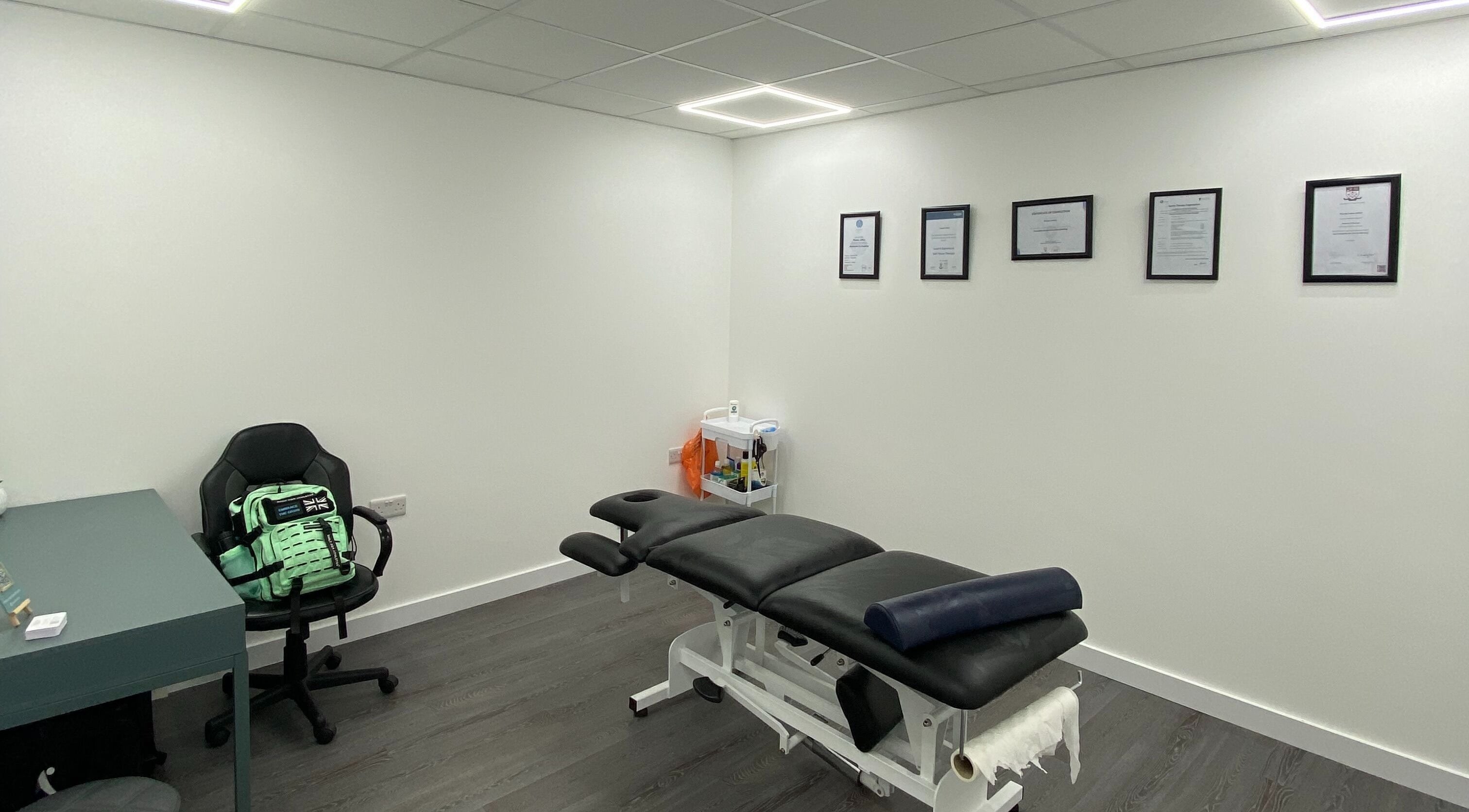 Modern therapy room at PJ Sports Rehab in Bideford, England, GB showcasing therapy table and seating.