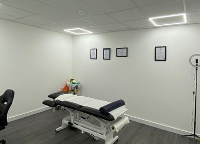 Modern treatment room at PJ Sports Rehab in Bideford, England, GB with massage table and certificates.