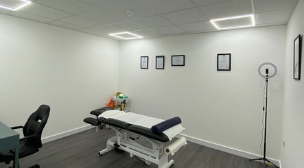 Modern treatment room at PJ Sports Rehab in Bideford, England, GB with massage table and certificates.