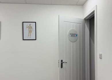 Entrance of PJ Sports Rehab in Bideford, England with anatomical art on the walls.