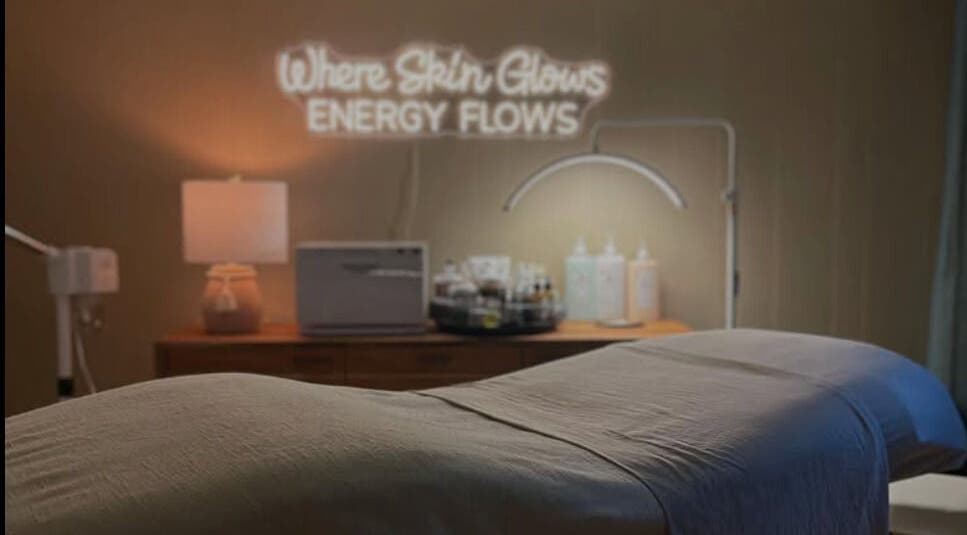 Relaxing spa room at Sarah Vlasblom in Ottawa, Ontario, CA. Cozy ambiance with a glowing sign and treatment bed.