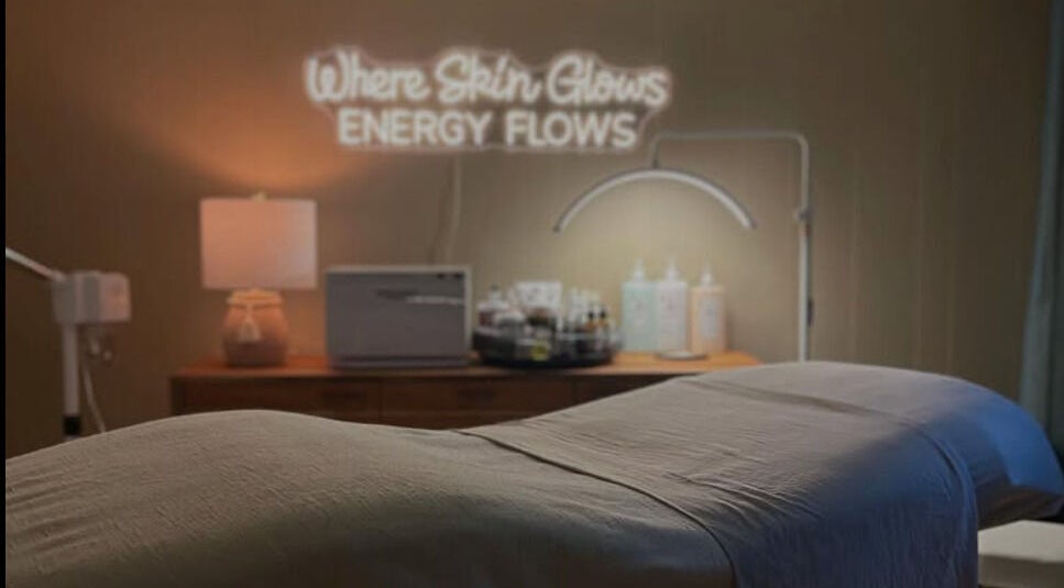 Relaxing spa room at Sarah Vlasblom in Ottawa, Ontario, CA. Cozy ambiance with a glowing sign and treatment bed.