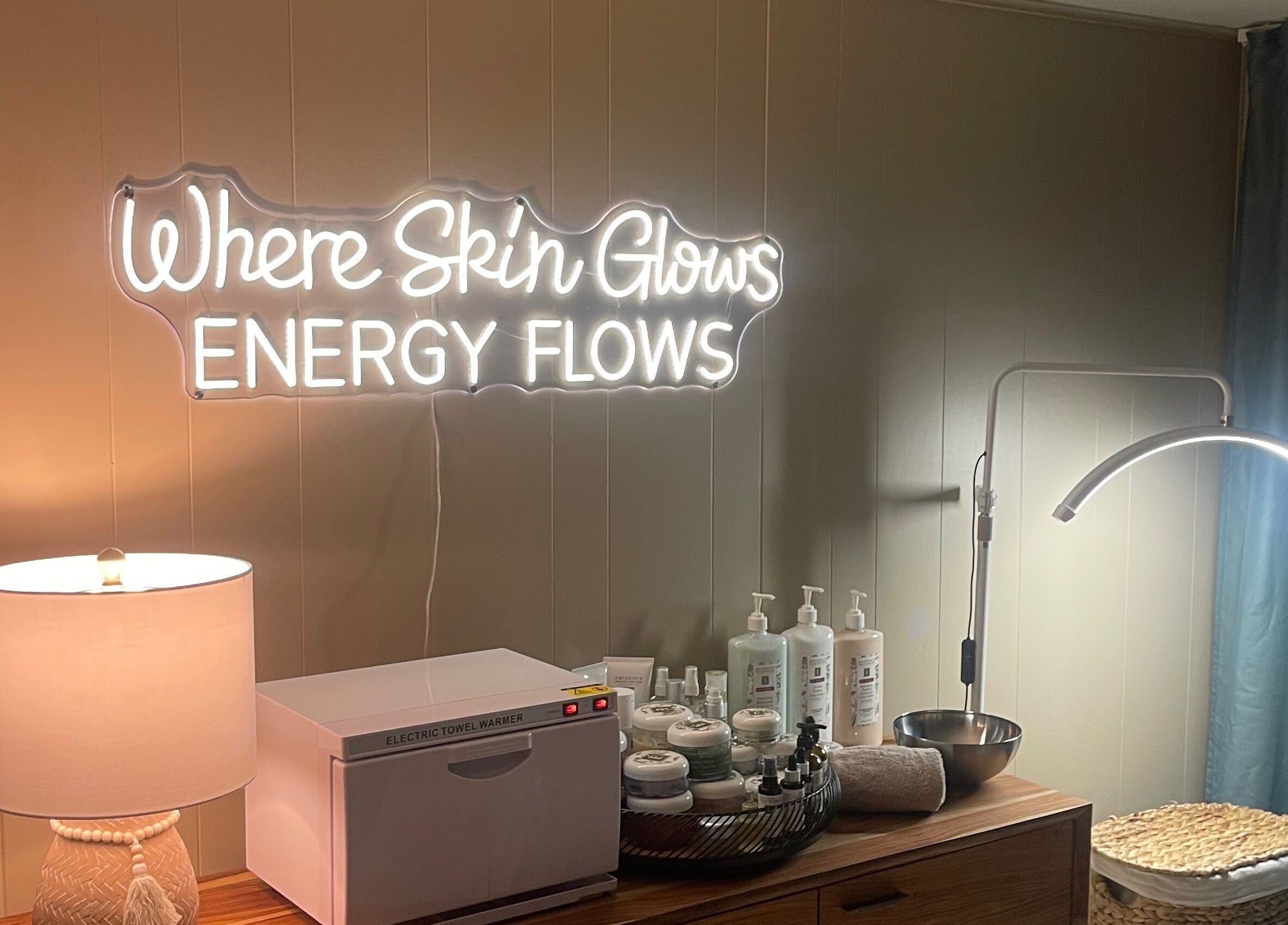Sarah Vlasblom spa in Ottawa, Ontario features a glowing neon sign with skincare products and gentle lighting.