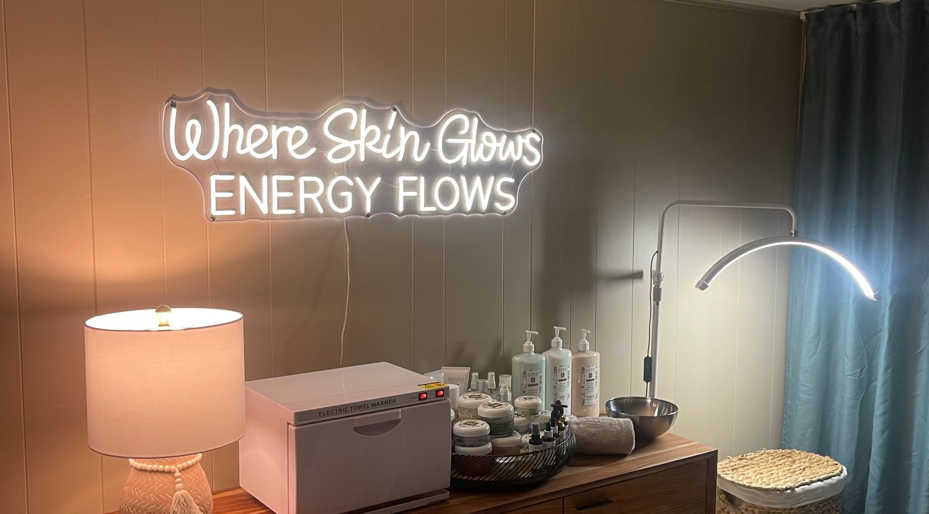 Sarah Vlasblom spa in Ottawa, Ontario features a glowing neon sign with skincare products and gentle lighting.
