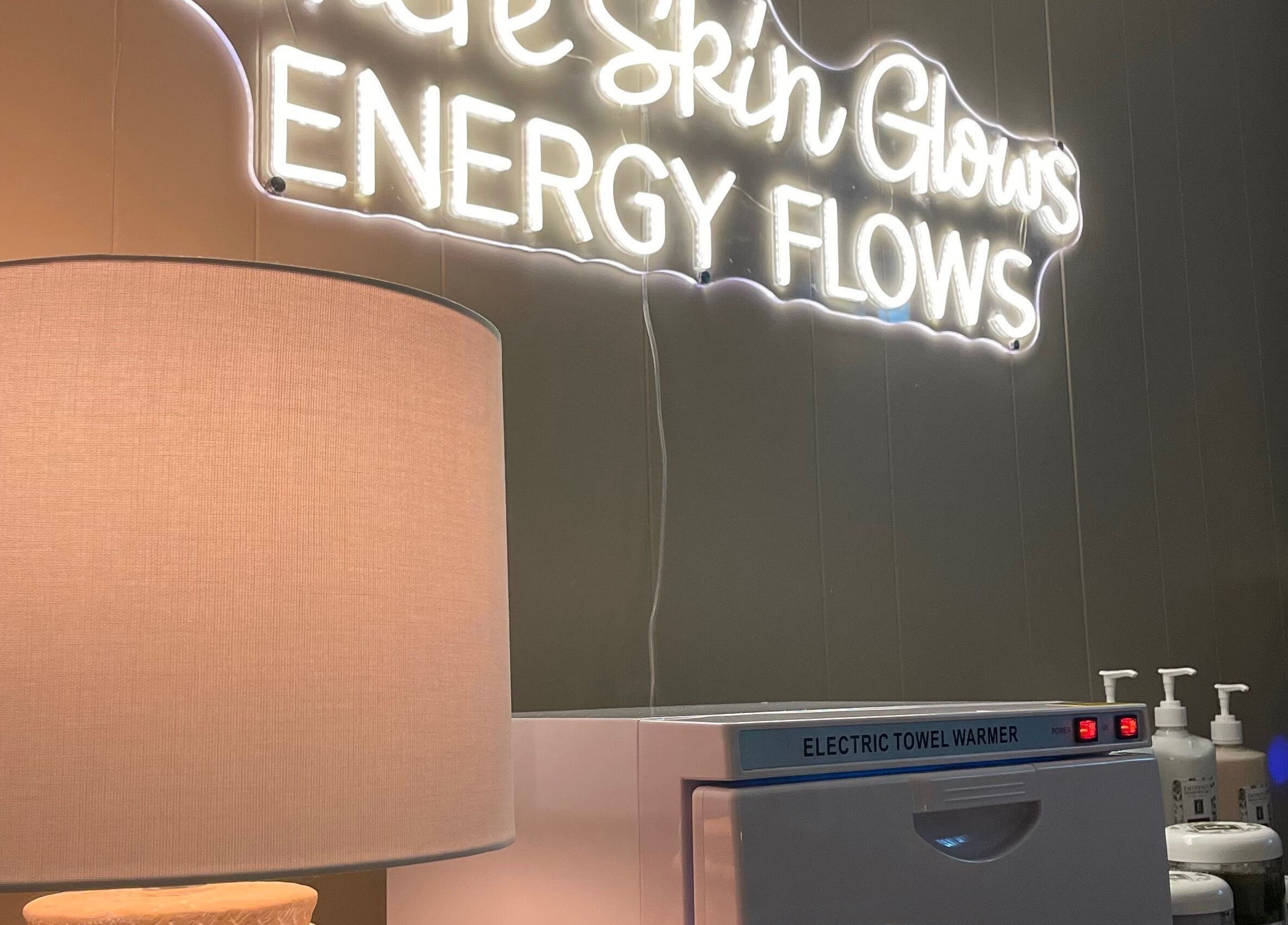 Elegant lamp beside neon sign at Sarah Vlasblom, Ottawa, Ontario, CA enhancing the spa's relaxing ambiance.