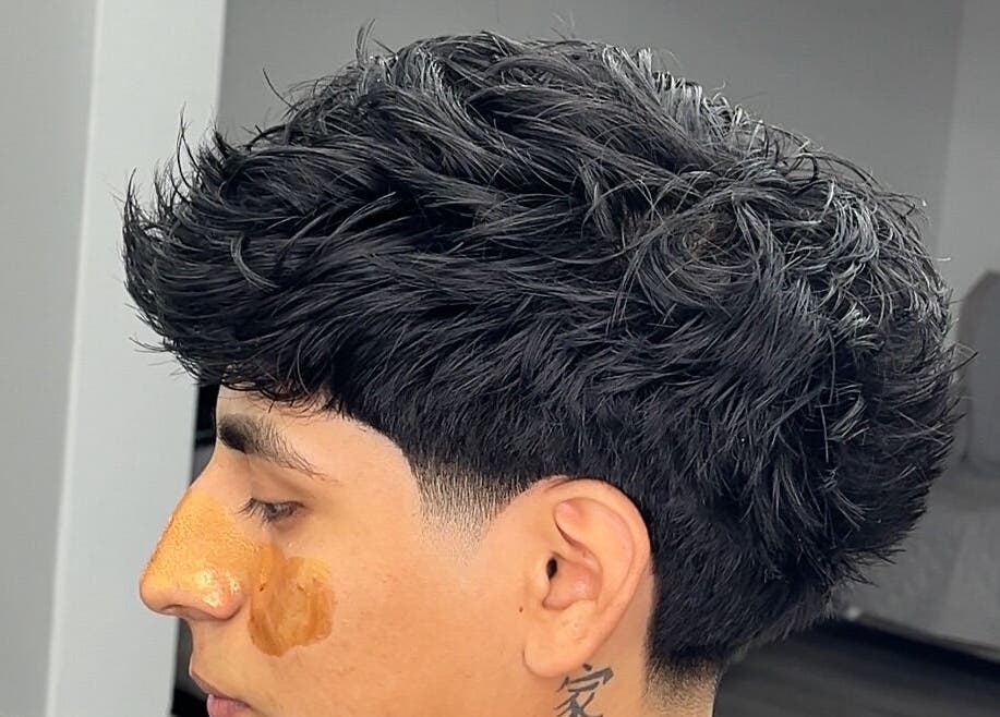 Peinado moderno en Barberia, Chimbote, Áncash, PE, mostrando un estilo fresco y elegante.