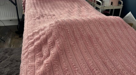 Soft pink treatment bed at Torvelle Beauty, Churchdown, England, GB, showcasing comfort and elegance.