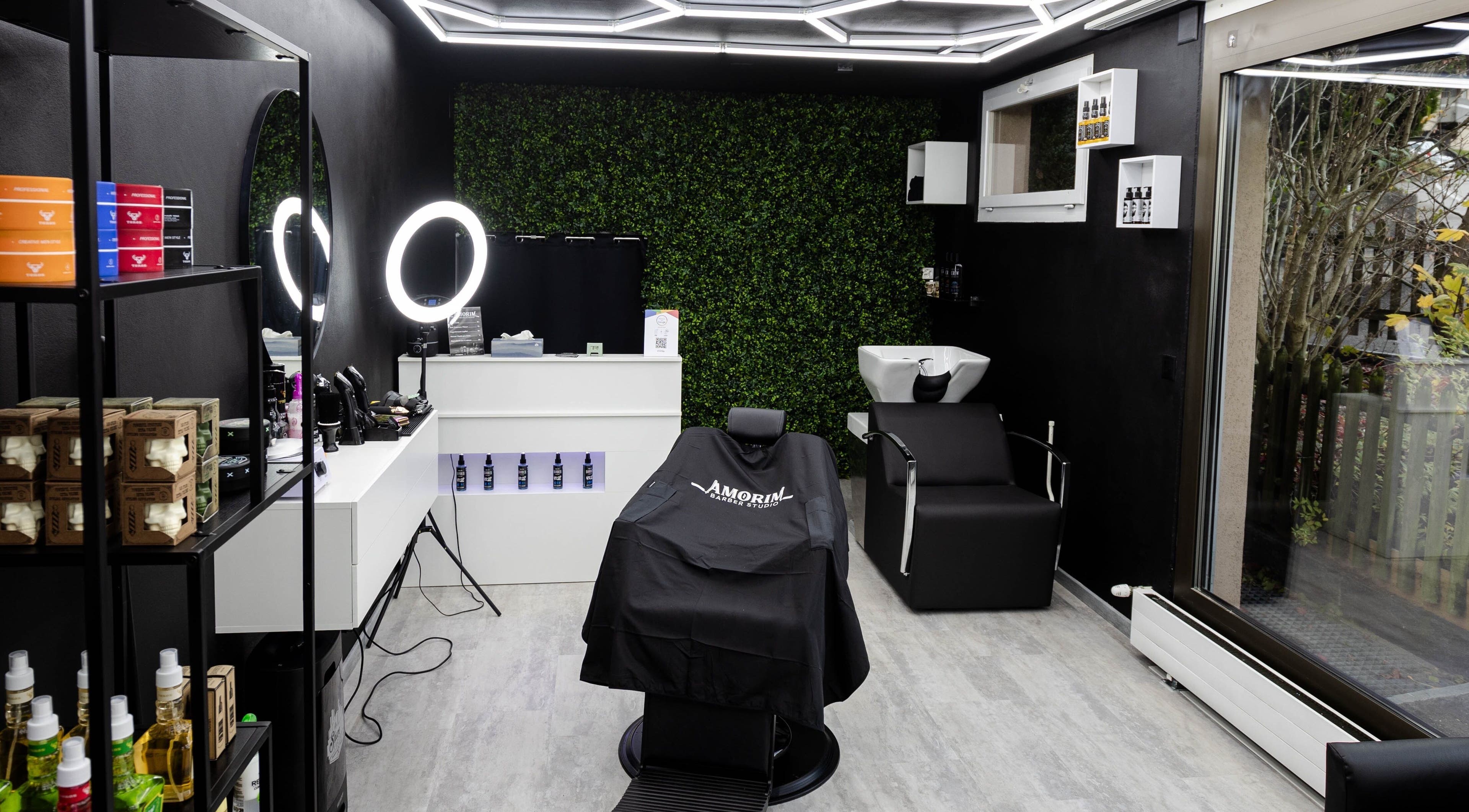 Innenansicht von Amorim Barber Studio, St. Gallen, elegantes Design mit Spiegeln und modernen Stühlen.