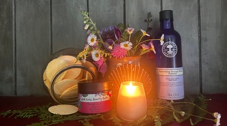 Serene display at Bethesda Beauty, Rawdon, England with candle, flowers, and wellness products.
