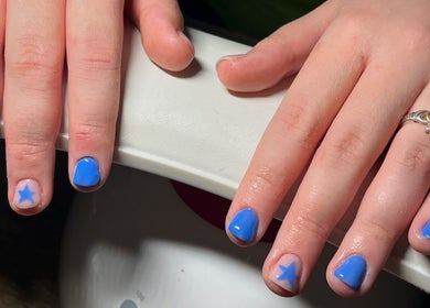 Stylish blue manicure with star accents at EM Nails, Belfast, Northern Ireland, GB.