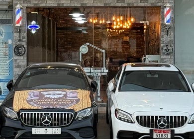 واجهة صالون الهرم الخامس للحلاقة الرجالية في الرياض, منطقة الرياض, SA بجانبه سيارات فاخرة.