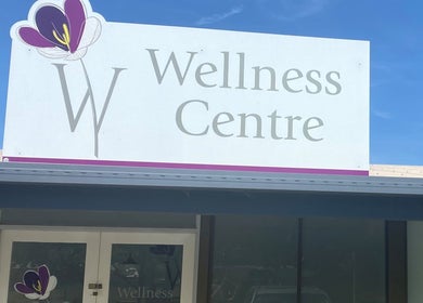 Entrance sign of W Wellness Centre in Bungendore, New South Wales, AU under a clear blue sky.