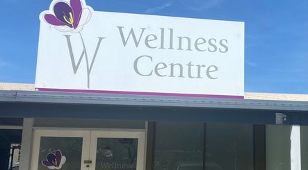 Entrance sign of W Wellness Centre in Bungendore, New South Wales, AU under a clear blue sky.