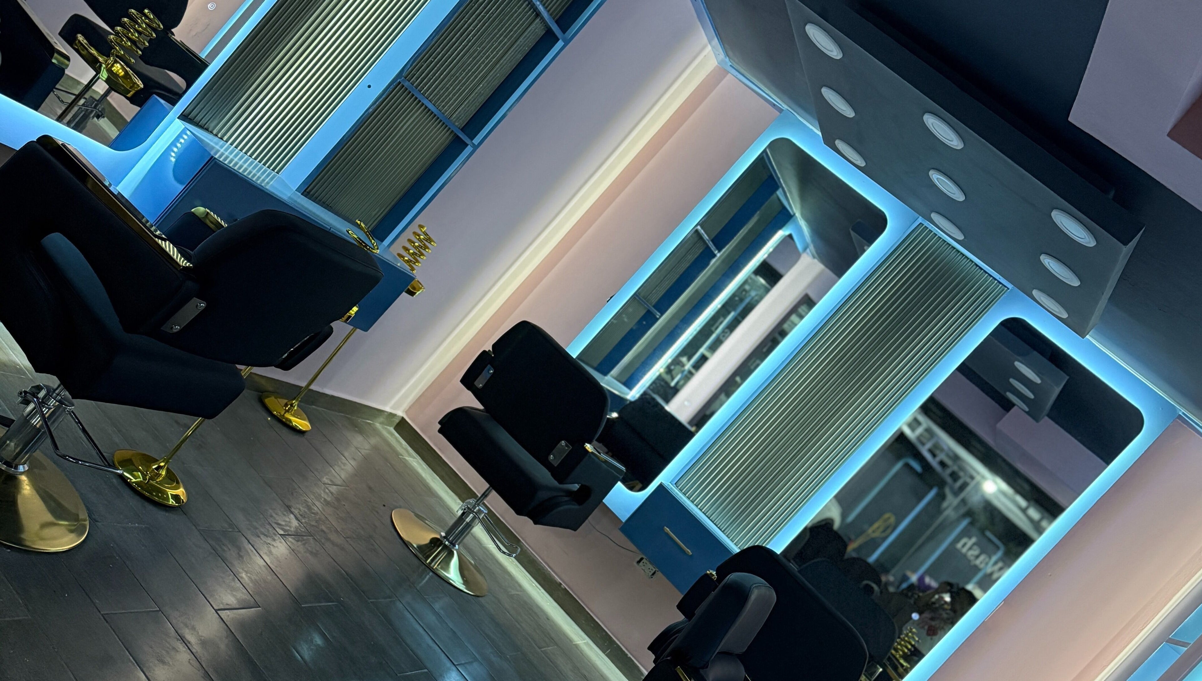 Interior moderno de Blue's Beauty Club en San Francisco De Macorís, Duarte, DO, con sillas y espejos iluminados.