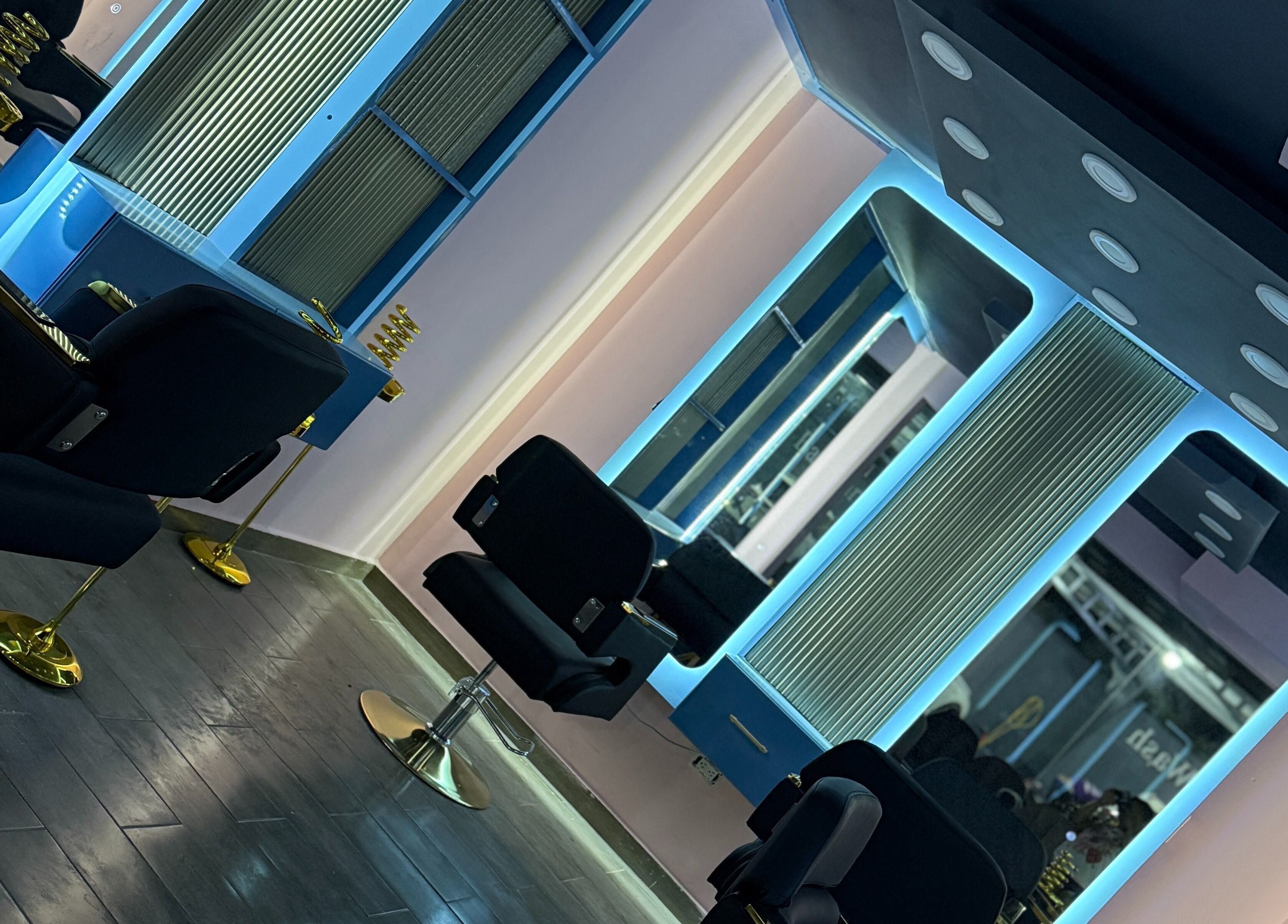 Interior moderno de Blue's Beauty Club en San Francisco De Macorís, Duarte, DO, con sillas y espejos iluminados.